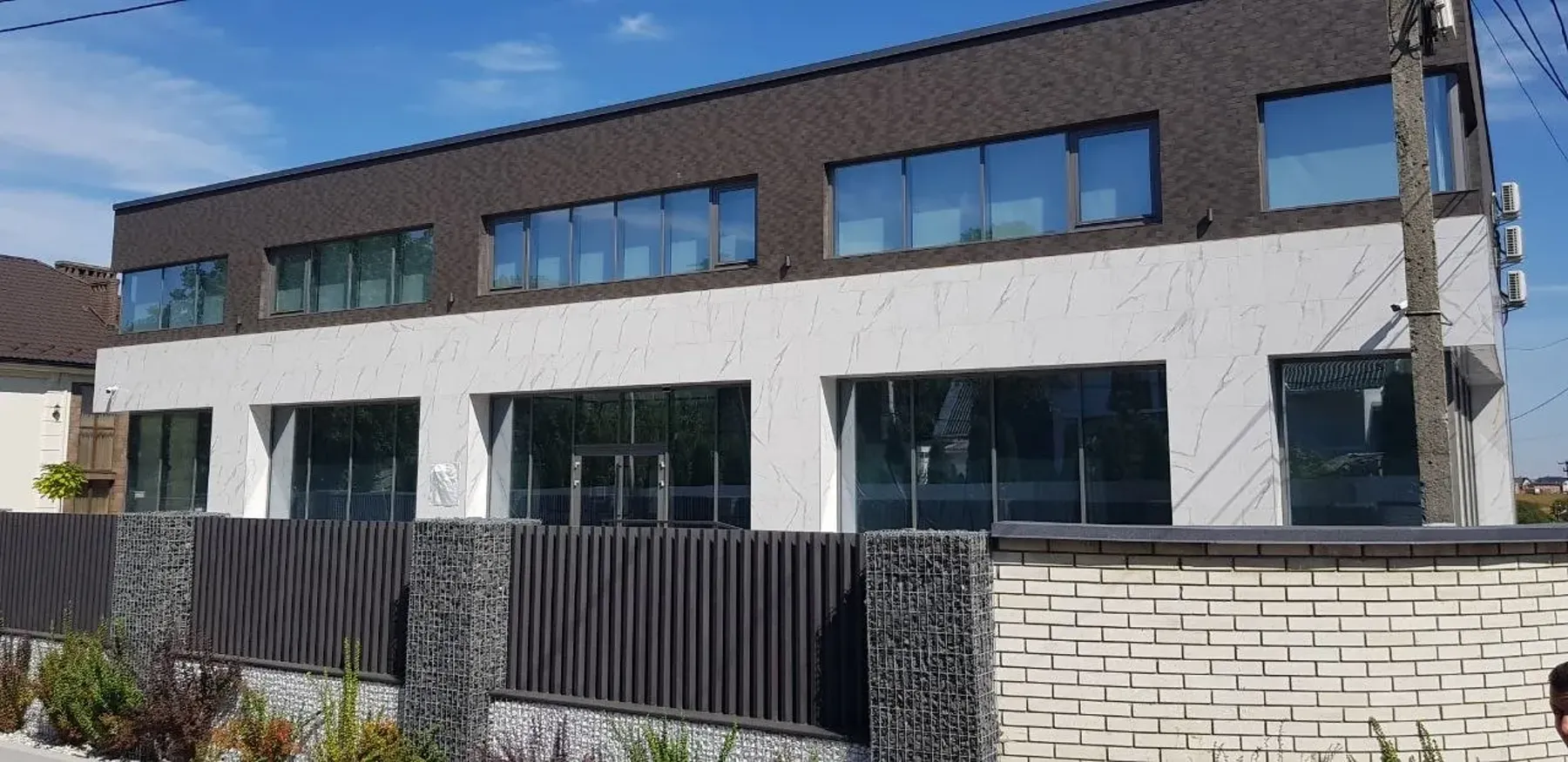 Будівля з вентильованим фасадом із композитних панелей і стрічковим склінням